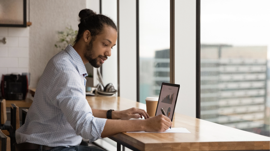 A business worker views financial charts and data on their laptop