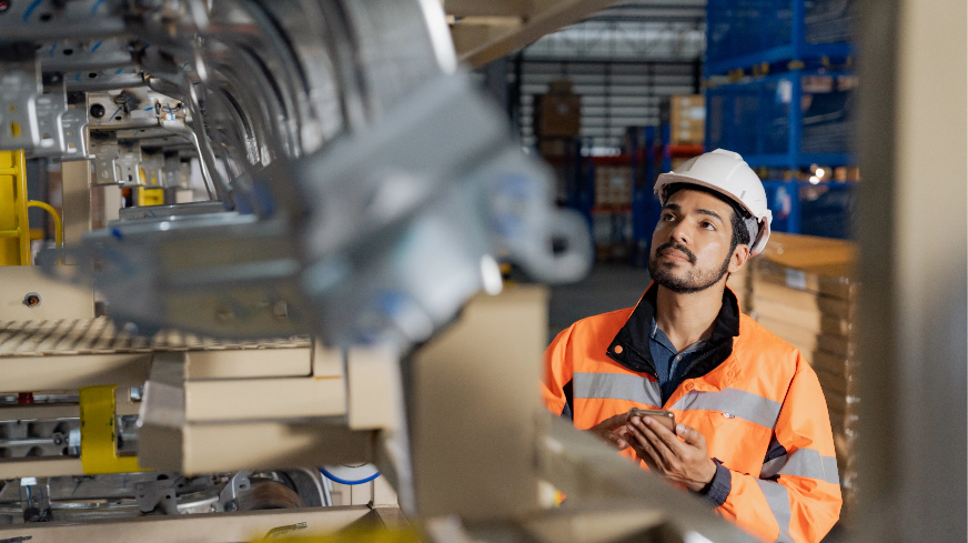 A worker inspects machinery on an assembly line