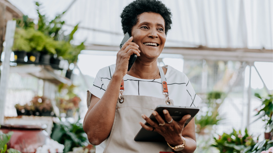 A plant shop owner answers the phone at their job