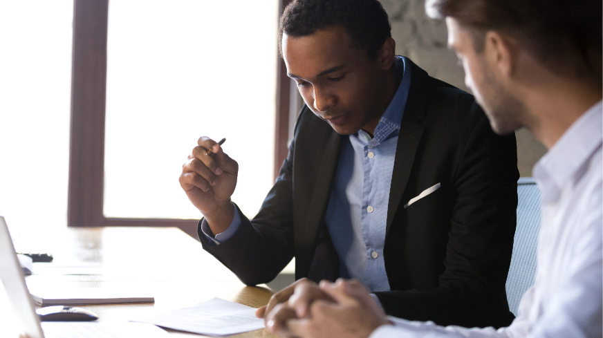 A client and agent review a contract in a conference room